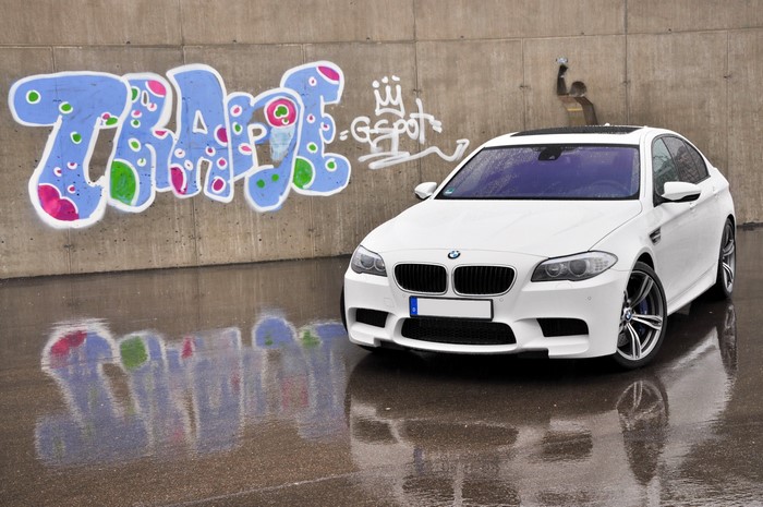 White BMW M5 F10 parked by graffiti wall