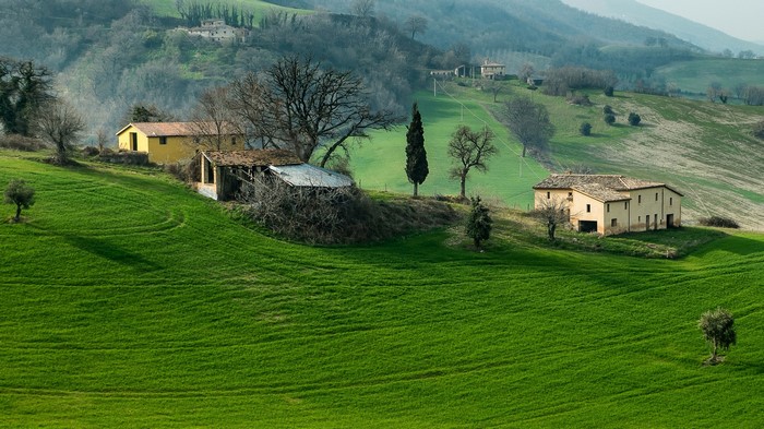 Italian countryside with rolling green fields and houses
