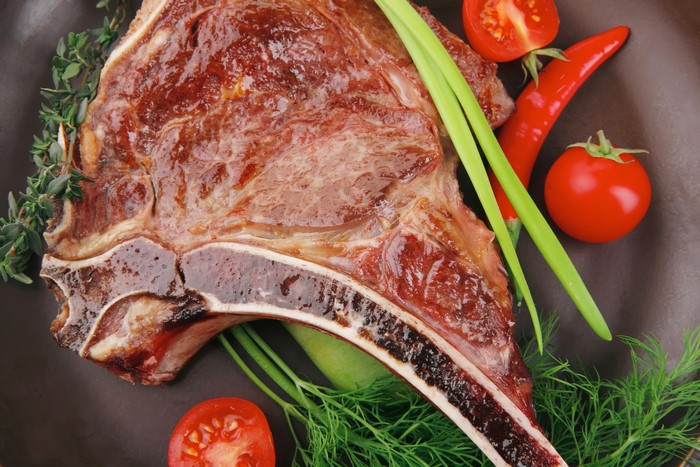 Cooked Ribeye Steak with Tomatoes and Herbs