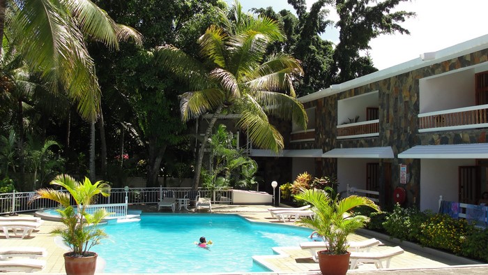 Swimming pool and hotel building with palm trees