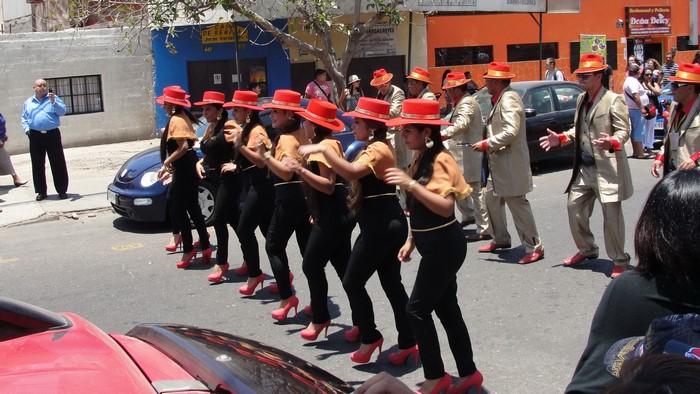 People in red hats and costumes in a street parade