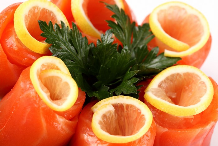 Salmon rolls with lemon slices and parsley