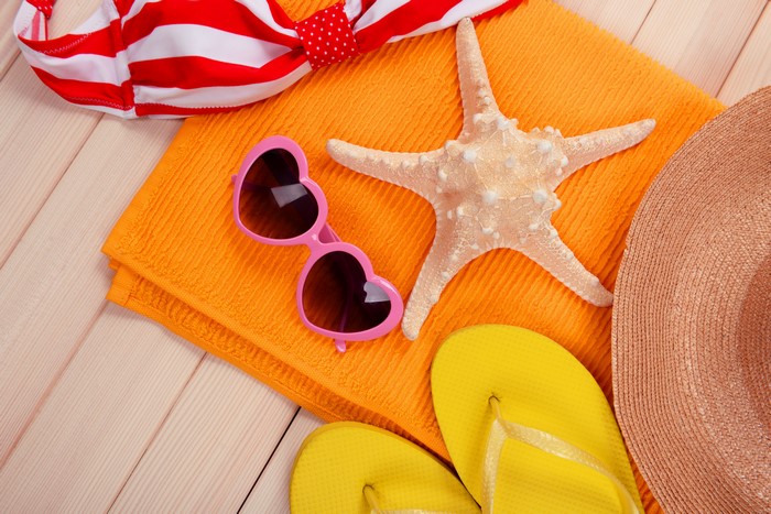 Beach accessories: bikini, sunglasses, starfish, flip-flops, hat