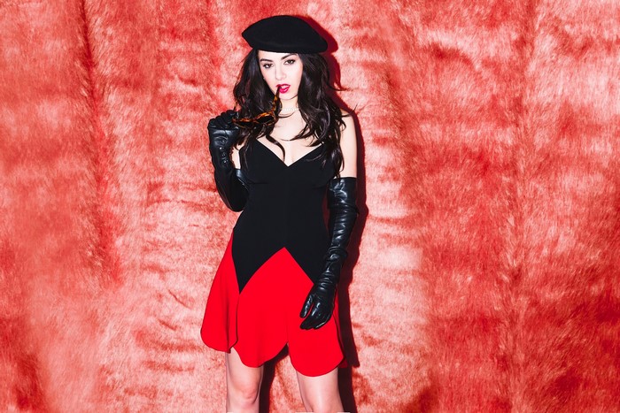 Charli XCX wearing a black and red dress and black gloves