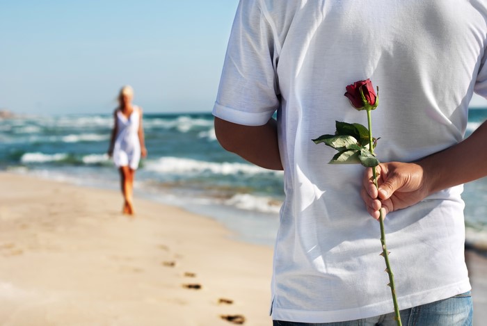 Couple on beach with rose