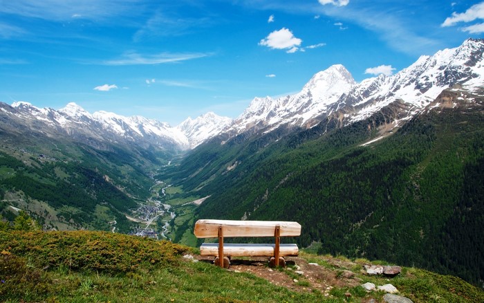 Wooden bench overlooking a valley in the Swiss Alps