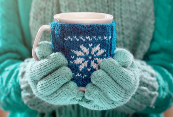 Hands in Gloves Holding a Winter Mug