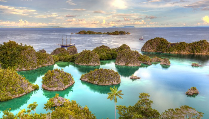 Islands and sailboats in Raja Ampat, Indonesia