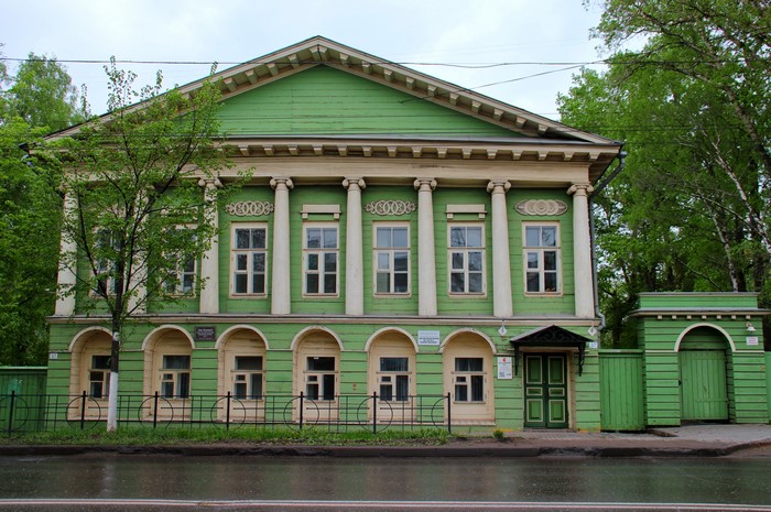 Green wooden house with columns in Vologda, Russia