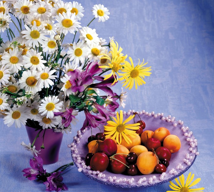 Still life with bouquet of daisies and fruit in a plate