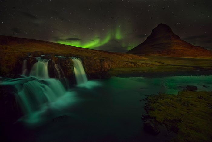 Kirkjufell mountain and waterfall under Aurora Borealis in Iceland