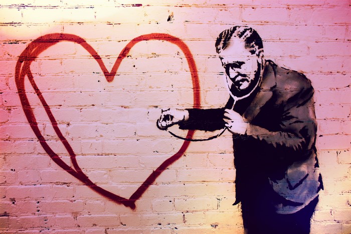Graffiti of a man with a stethoscope and a heart on a wall