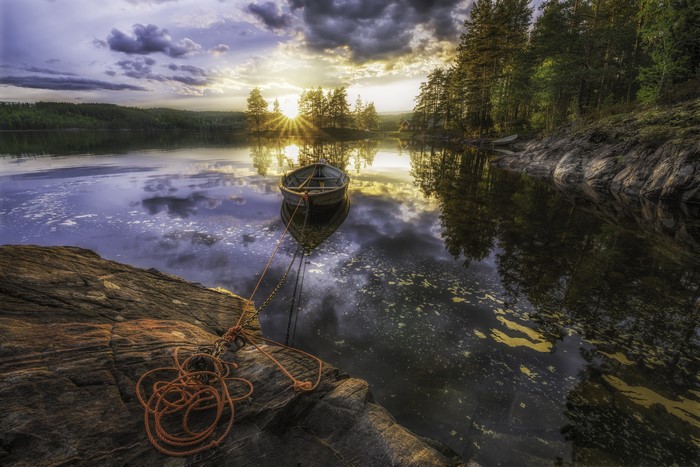 Boat on a lake at sunset with rocky shore