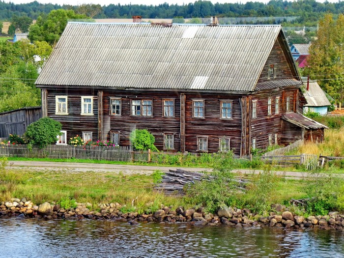Wooden house by the river in a Russian village