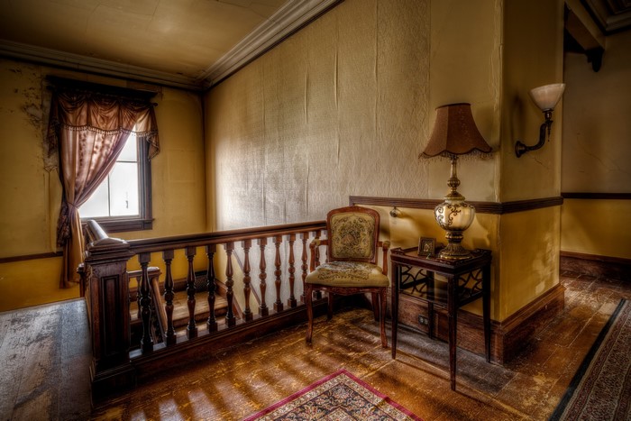 Interior of an abandoned house with stairs and furniture