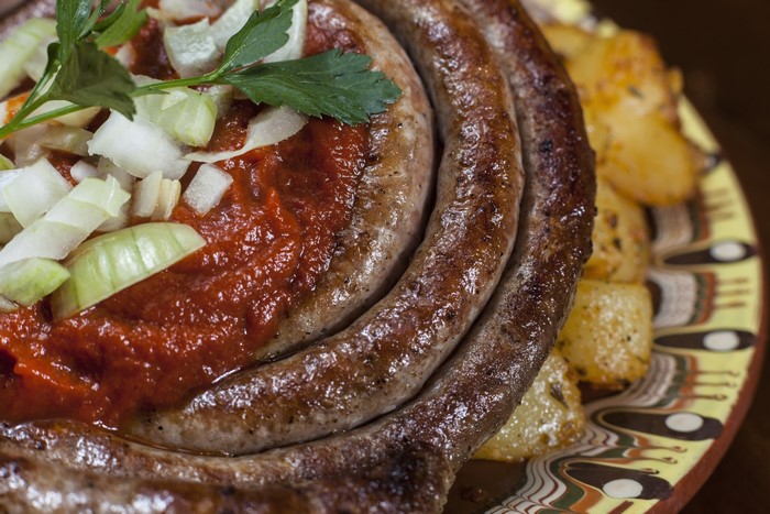 Sausage with sauce and potatoes on a plate