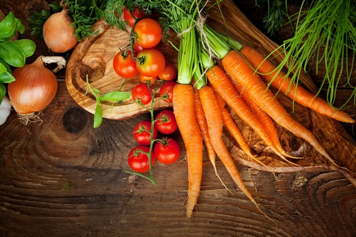 Tomatoes, Carrots, and Onions on a Wooden Table