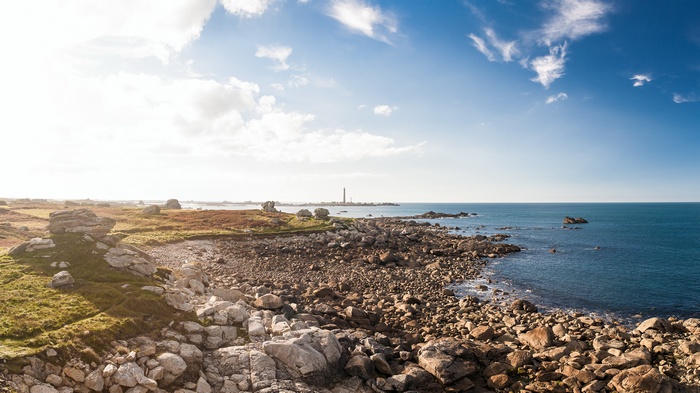 Rocky coastline with a lighthouse in the distance