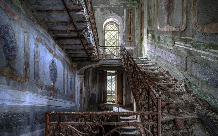 Abandoned building interior with decaying staircase
