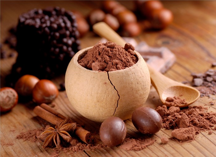 Chocolate powder, hazelnuts, cinnamon, and star anise on wood