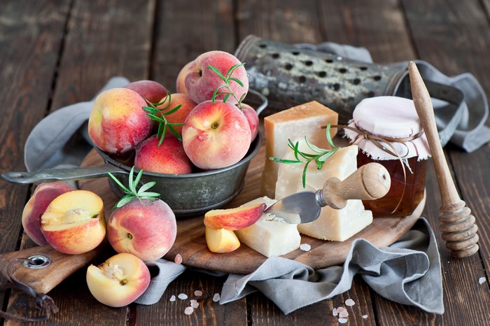 Peaches, Cheese, and Honey on Wooden Table