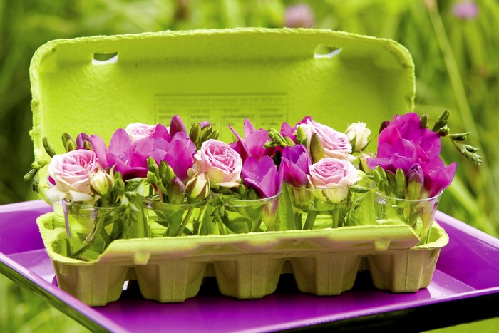 Pink roses and purple freesia in egg carton