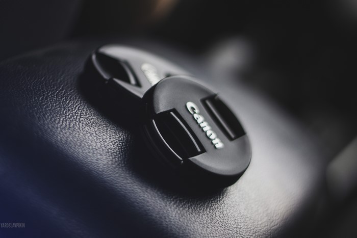 Canon camera lens cap on textured surface