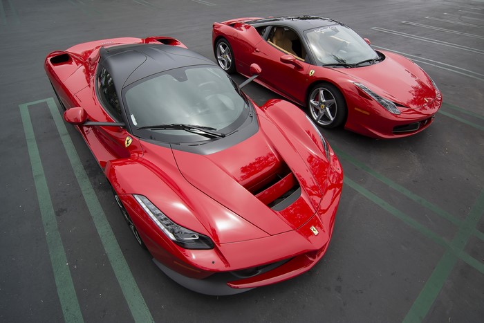 Two red Ferraris parked on asphalt