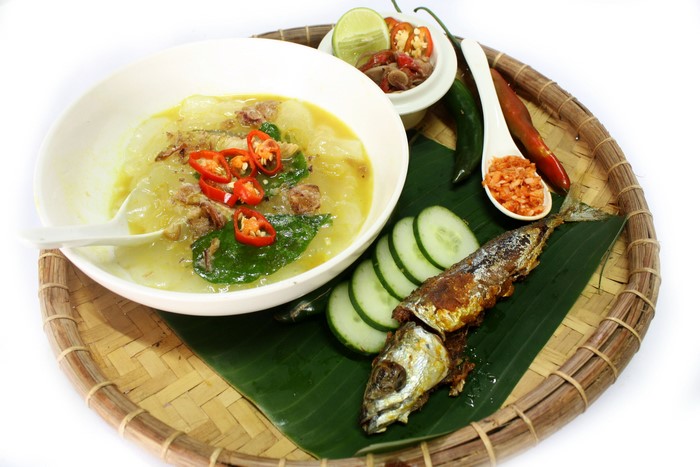 Soup with fish, vegetables, and chili on a tray