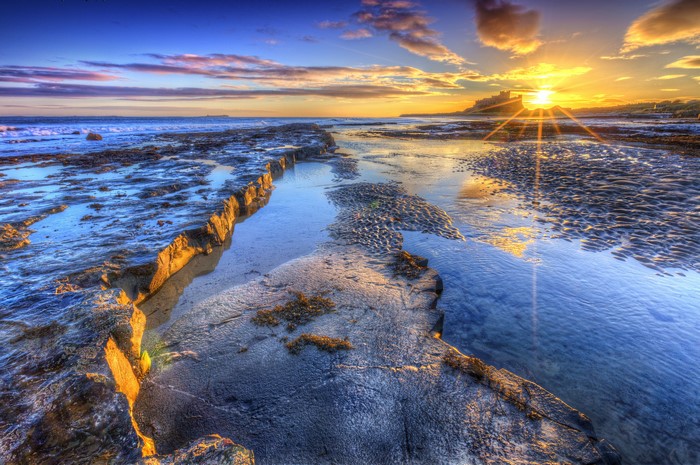 Sunset Rays Over Rocky Coastal Landscape 4K