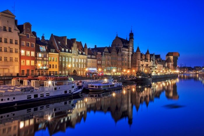 Gdańsk waterfront with ships and historic buildings at night