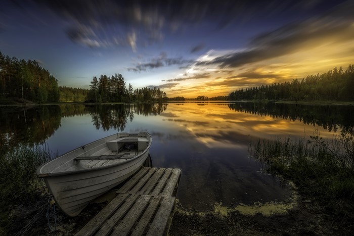 Boat docked on a lake at sunset