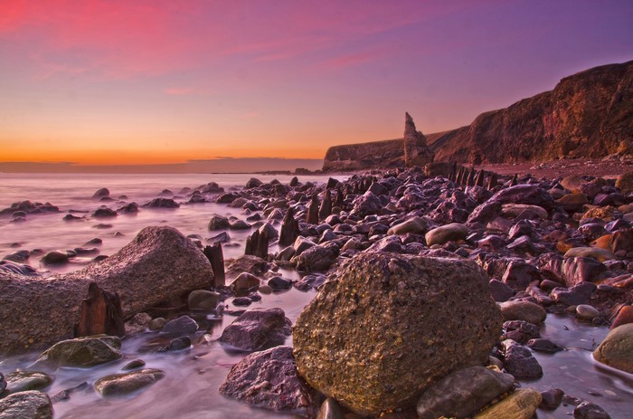 Rocky coast with sea and colorful sunset sky