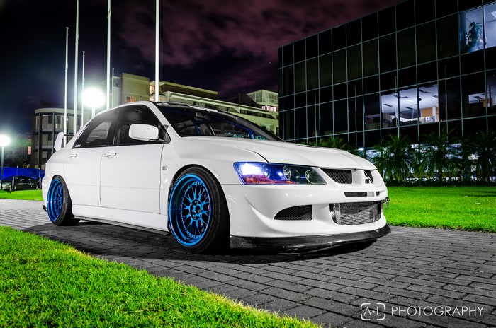 White Mitsubishi Lancer Evolution with blue rims