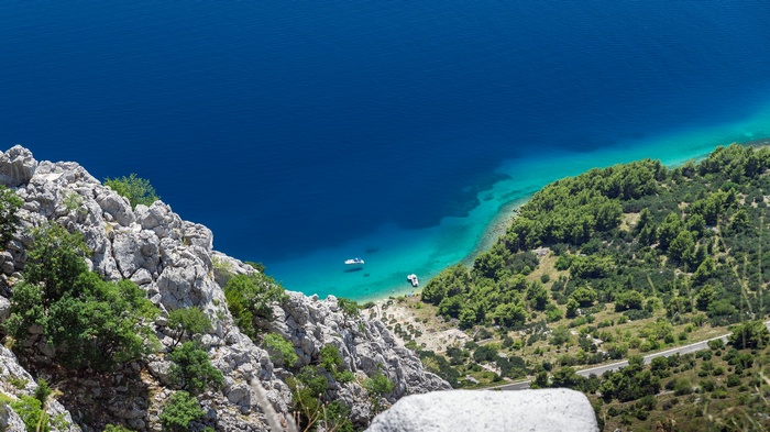 View from mountain overlooking turquoise sea and rocky coast