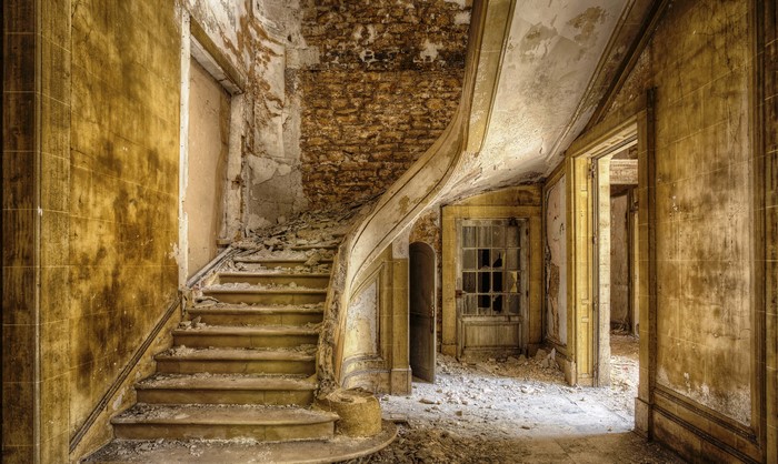 Abandoned building interior with decaying staircase
