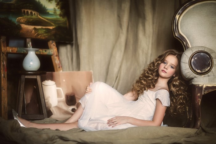 Young girl in a white dress lying down