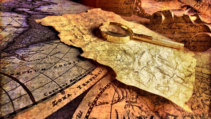 Magnifying glass on old maps and parchment with writing