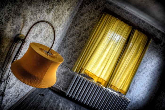 Yellow lamp and curtains in an abandoned room