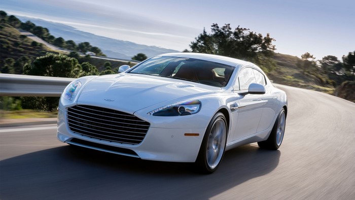 White Aston Martin Rapide S driving on a winding road