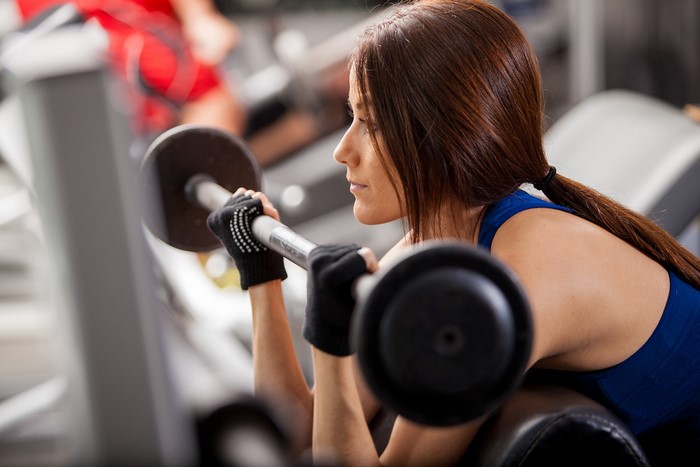 Woman lifting barbell in gym