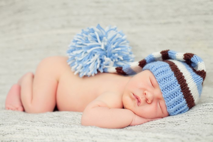 Newborn baby sleeping in a striped hat
