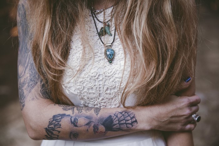 Woman with tattoos and necklaces