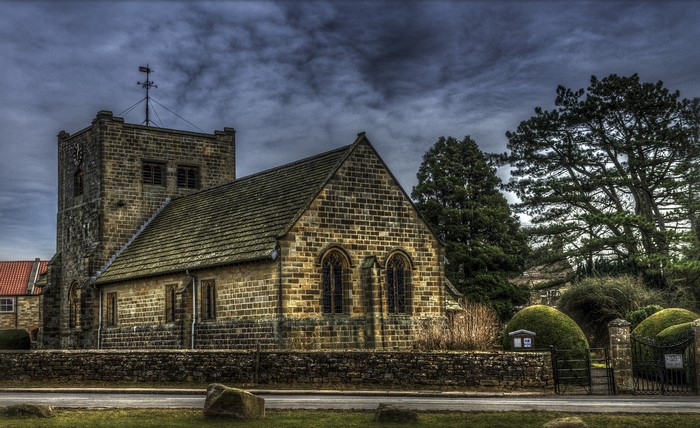 Stone church with tower and fence