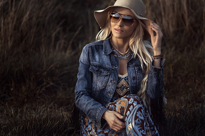 Blonde woman wearing a denim jacket and hat