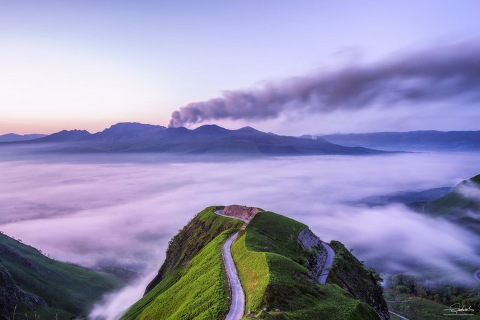 Volcanic smoke over mountains above a sea of clouds