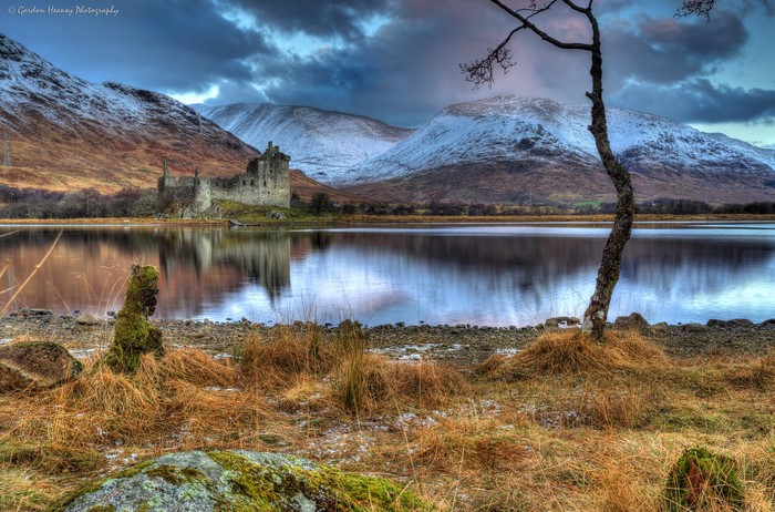 Kilchurn Castle on a lake in Scotland with mountains