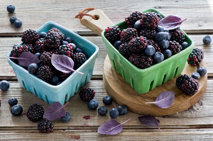 Blackberries and blueberries in colorful baskets