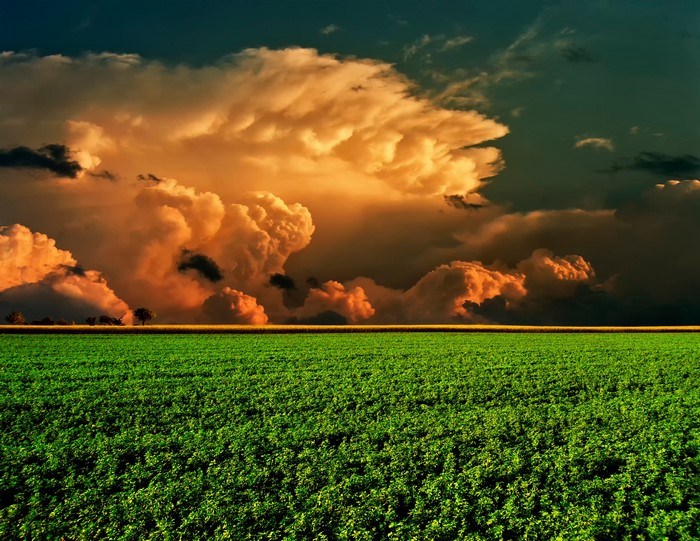 Green field under dramatic storm clouds
