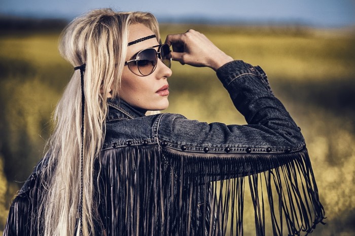 Blonde woman with sunglasses and fringe jacket